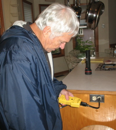 Dan inspecting a home's electrical outlets.
